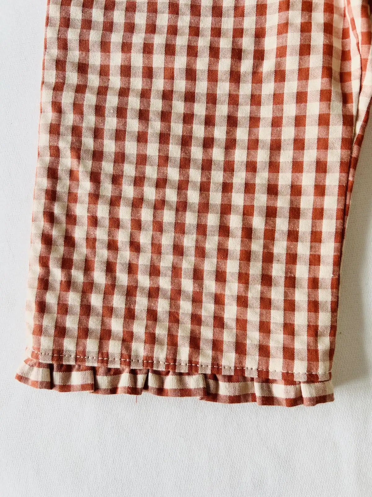 Détail matière seersucker naturelle et petit nœud sur pantalon bébé fille artisanal.
