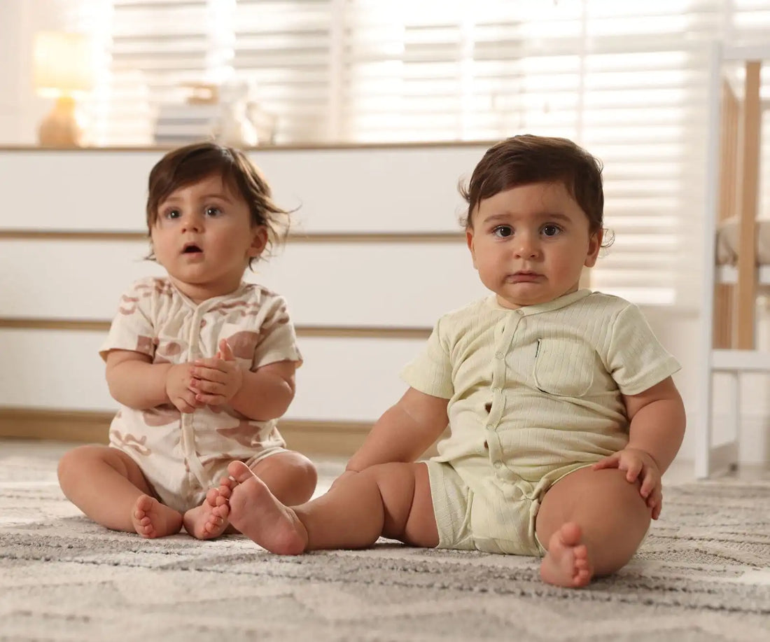 Deux bébés assis sur un tapis dans une chambre lumineuse en tenues assorties