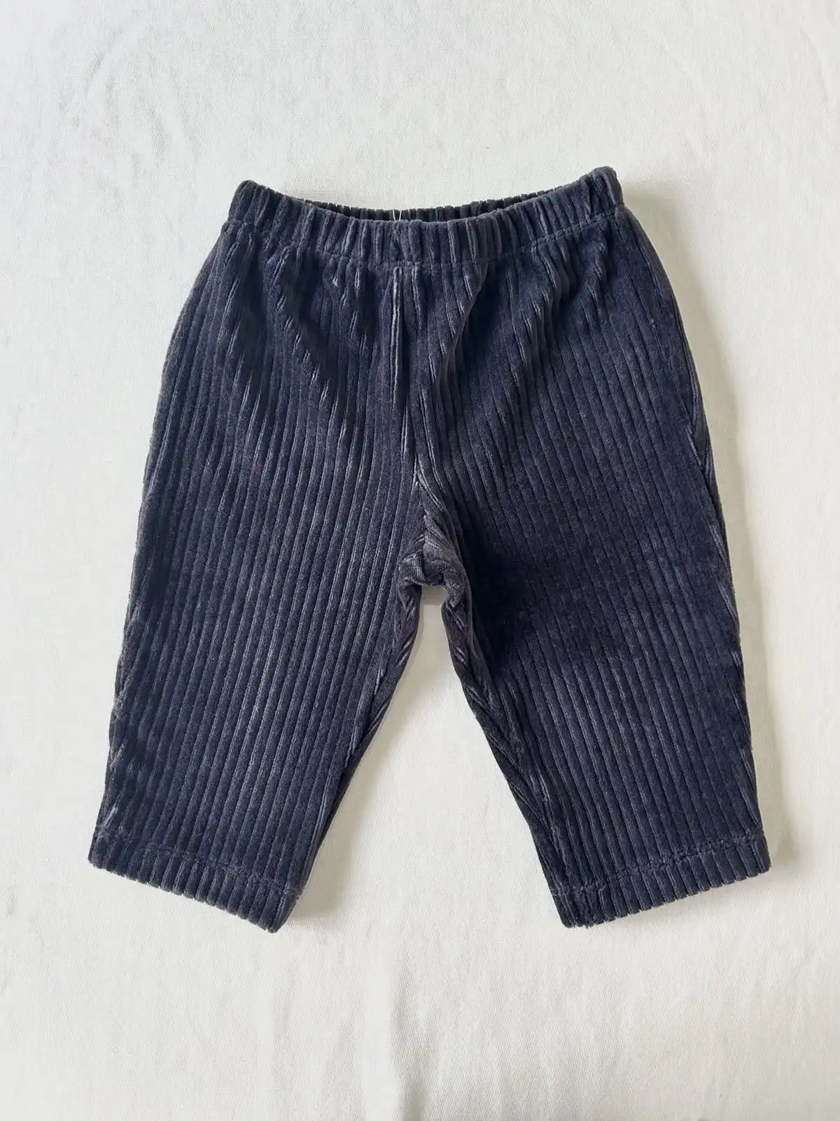 Détail du tissu velours côtelé marine et de la taille élastique du pantalon bébé