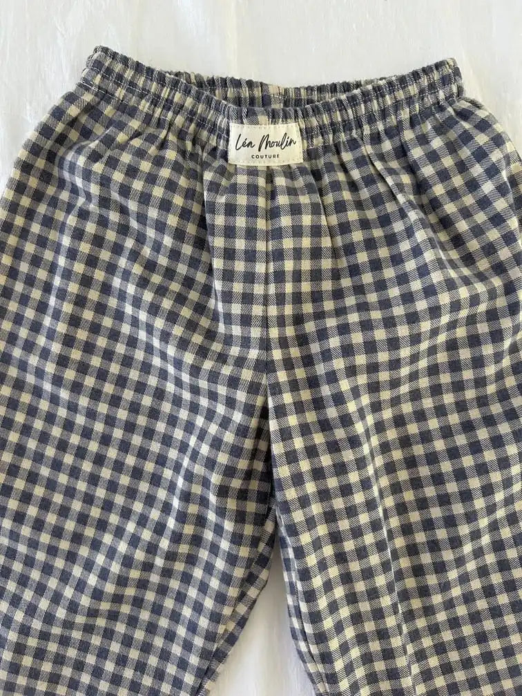 Taille élastiquée et étiquette Léa Moulin Couture d'un pantalon en coton vichy bleu marine et écru, vue de près