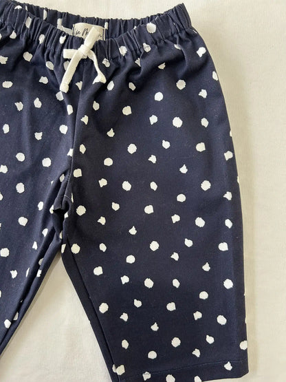 Gros plan sur la taille élastique, le cordon blanc et les pois blancs sur gabardine bleu marine