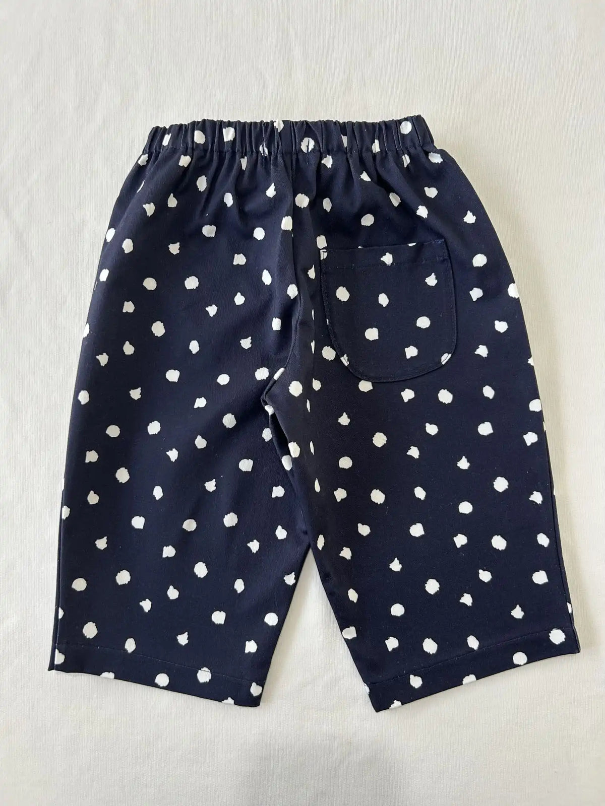Pantalon large bleu marine à pois blancs, vue de dos avec poche plaquée