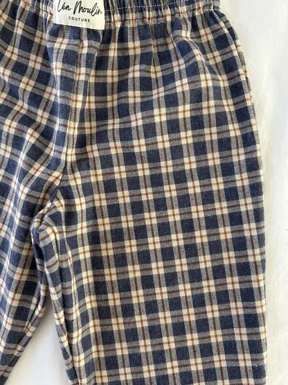 Taille élastiquée et étiquette Léa Moulin Couture d'un pantalon à carreaux bleu marine et écru, vue de près
