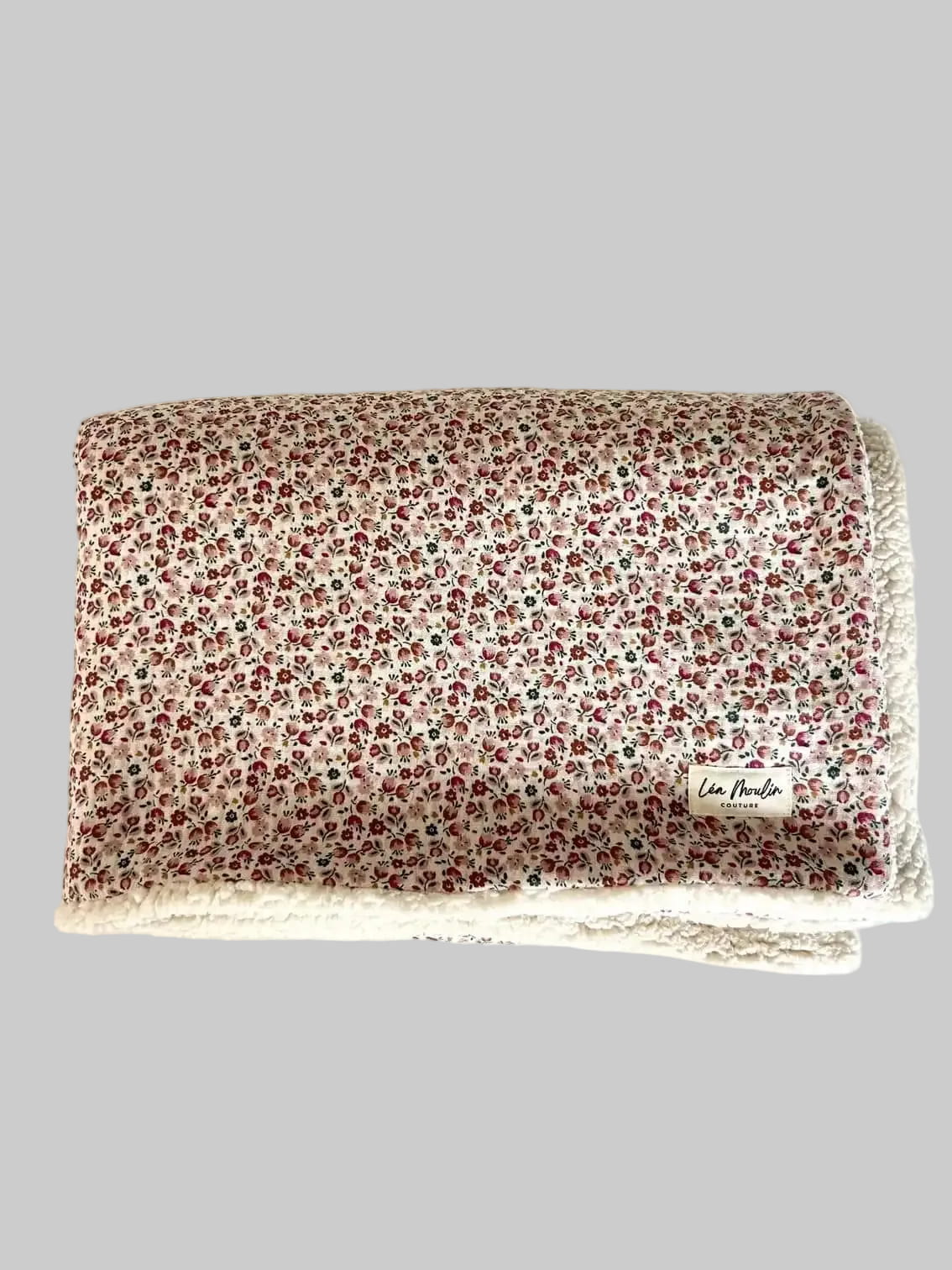 Couverture bébé en double gaze à petites fleurs roses et sherpa écru, pliée, vue de face