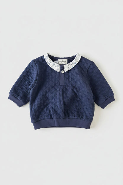 Détail du col en tissu Liberty et bouton unique sur encolure de l'ensemble en coton bleu.