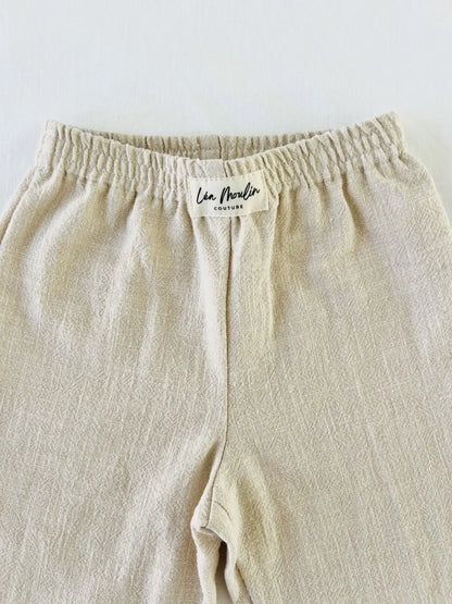 Pantalon bébé Ernest en lin et coton beige, taille élastiquée avec étiquette Léa Moulin Couture, vue arrière