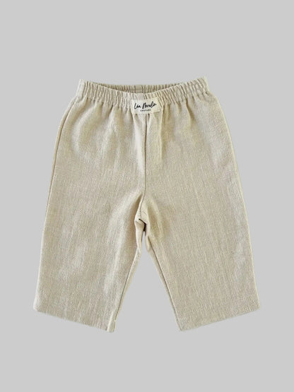 Pantalon bébé large en lin et coton beige, coupe droite, posé à plat vue de face