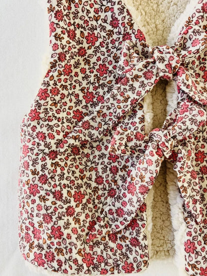 Détail imprimé fleuri et nœuds sur gilet bébé Julia.