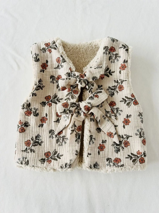 Gilet sans manches bébé motif fleuri beige et liens à nouer fait main.