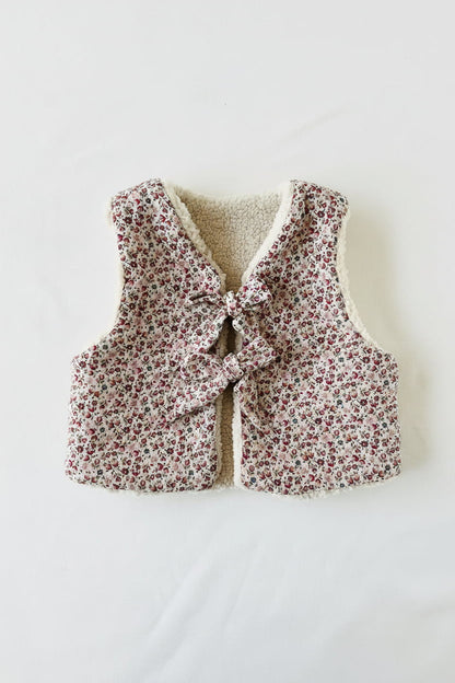 Gilet bébé fille réversible en sherpa et gaze de coton fleurie rose, vu de face avec fermeture à nœuds
