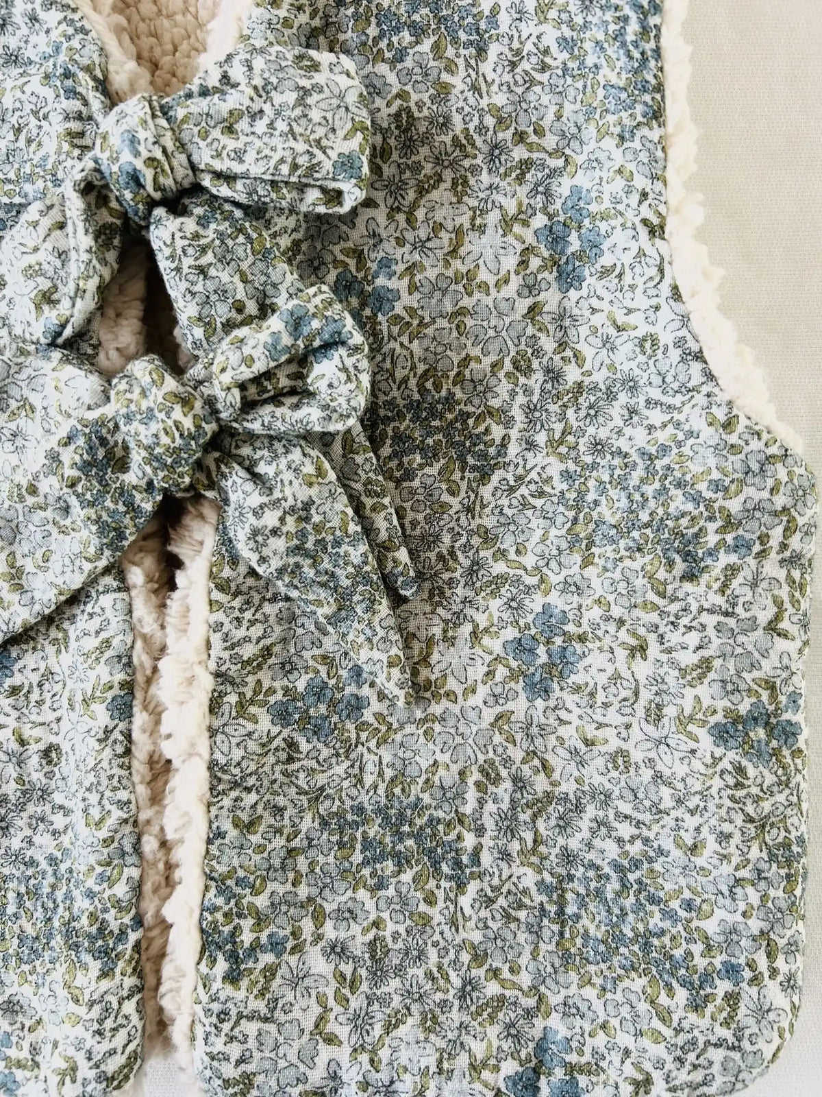 Détail d'un nœud en gaze de coton fleurie sauge, vert de gris et bleu gris