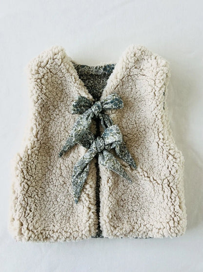 Gilet bébé réversible vu de dos côté sherpa écru moelleux avec nœud fleuri sauge