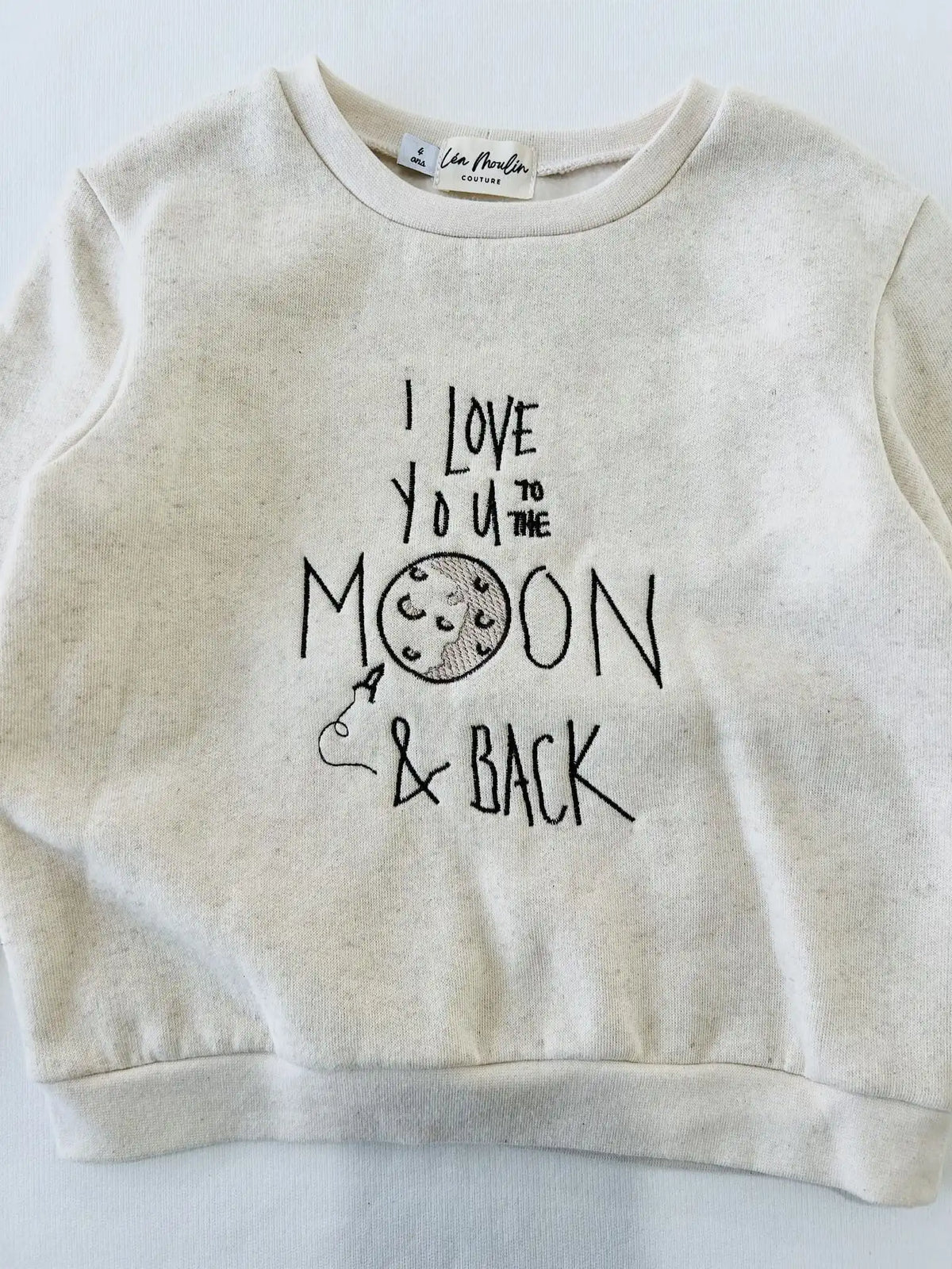 Détail de la broderie lune sur le sweat bébé en coton et lin chiné