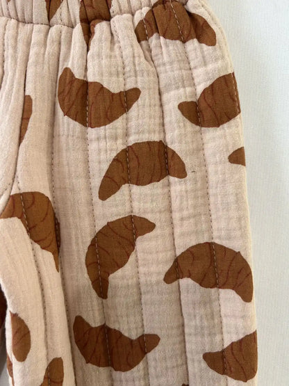 Gros plan sur le tissu de coton matelassé en bandes verticales, motif croissants caramel