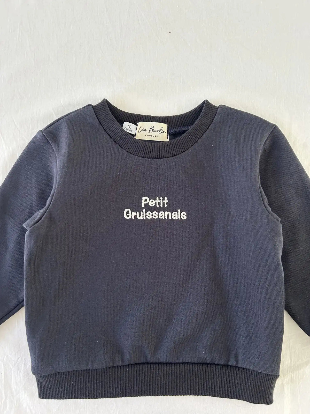 Détail broderie "Petit Gruissanais" sur sweat bébé bleu marine en coton - étiquette Léa Moulin Couture