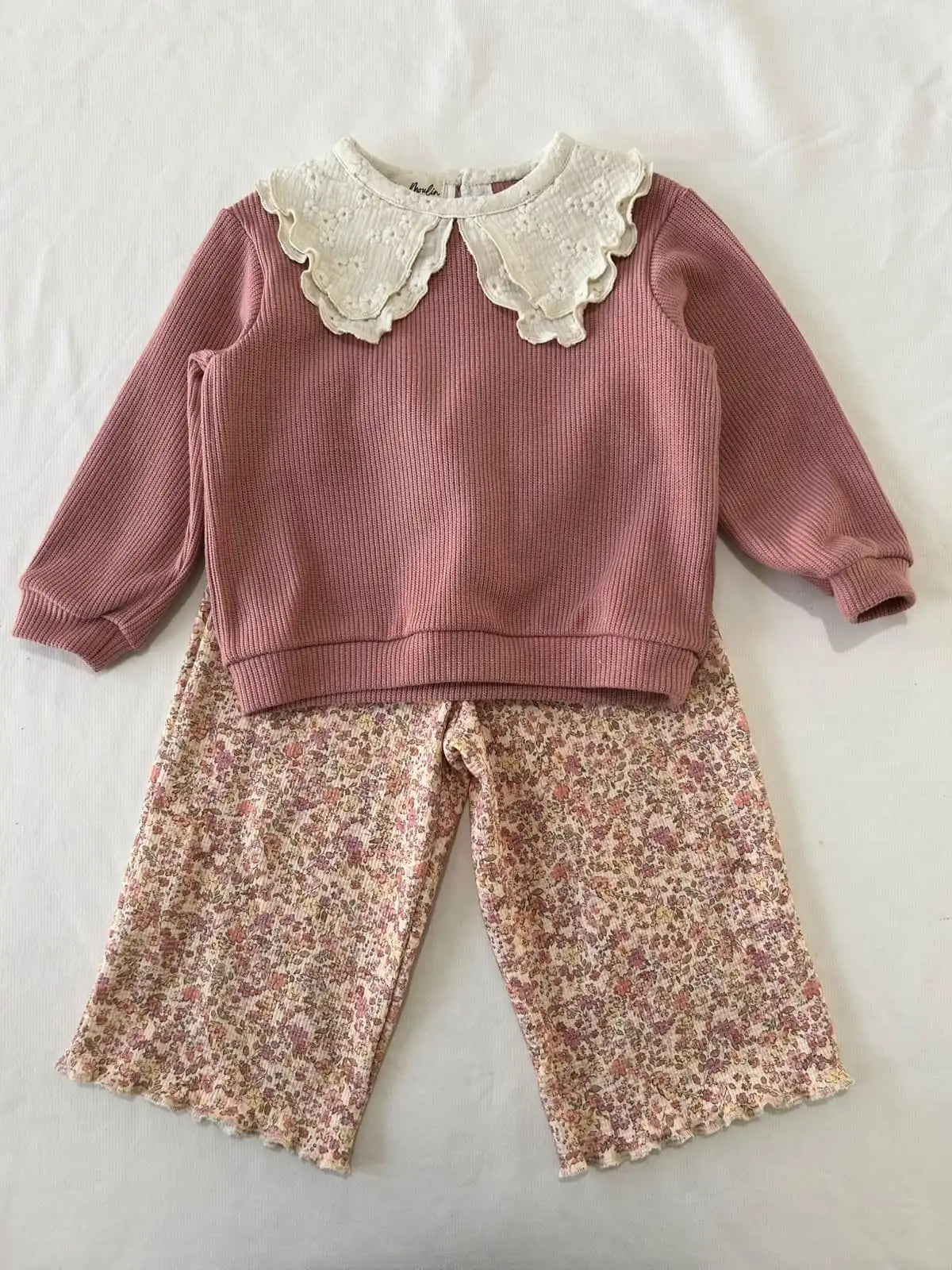 Pull bébé fille vieux rose à col brodé fleuri porté avec un pantalon large en coton fleuri