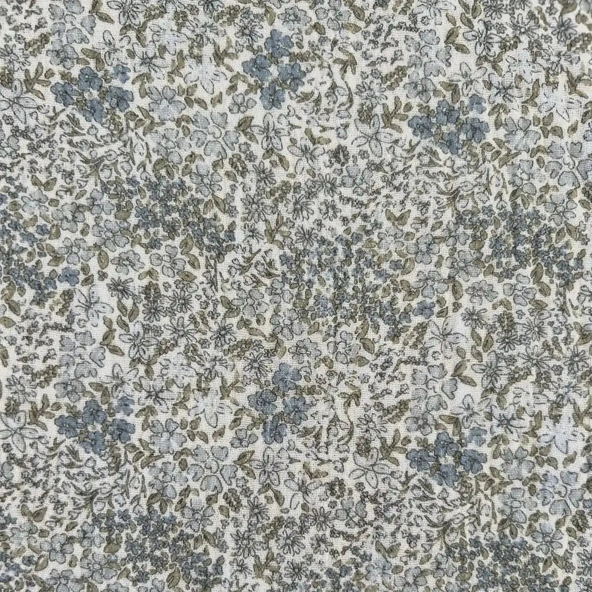 Gros plan sur le tissu fleuri sauge en double gaze de coton de la couverture bébé Simone