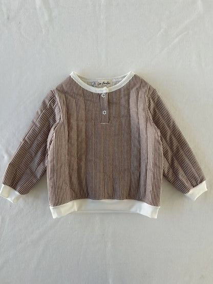 Détail pressions et bord-côte sur sweat bébé rayé.