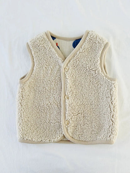 Gilet sans manches en sherpa écru avec trois boutons beiges et bordure côtelée beige, côté sherpa
