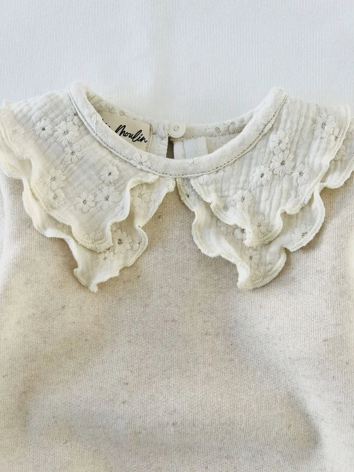 Détail du col volanté brodé de fleurs sur sweat enfant